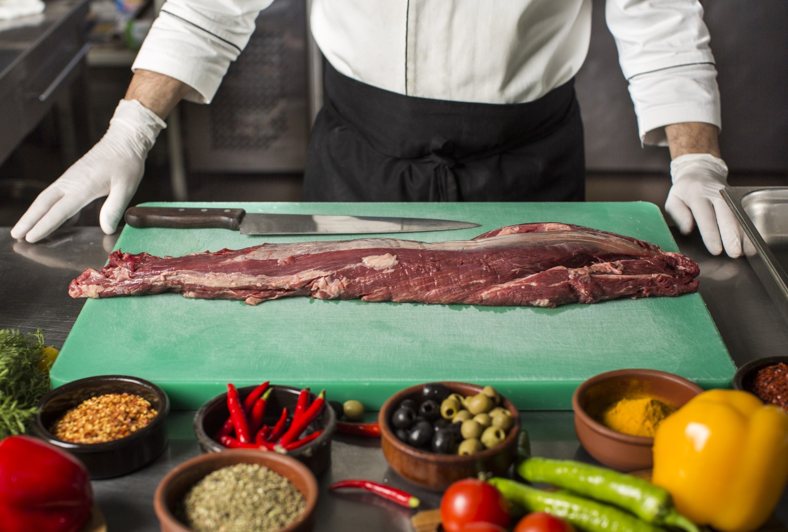 cocinero cortando la carne en restaurante